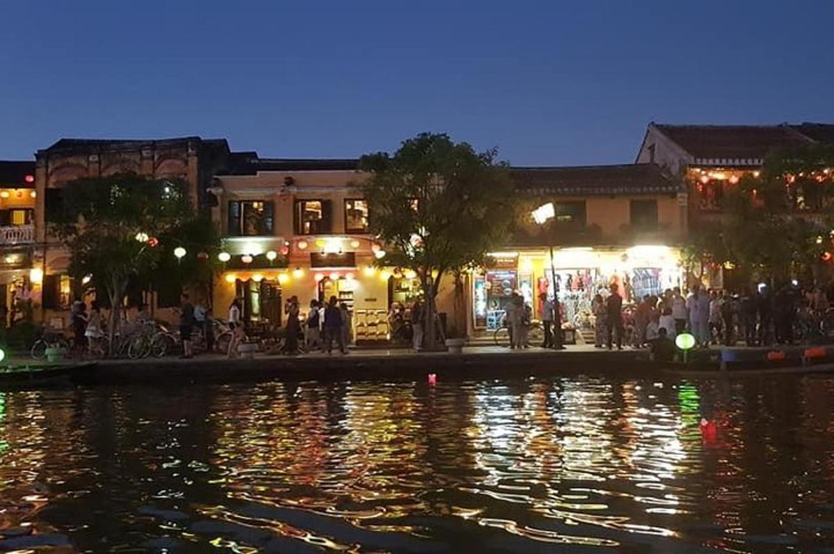 un gruppo di persone in piedi vicino a un fiume di notte