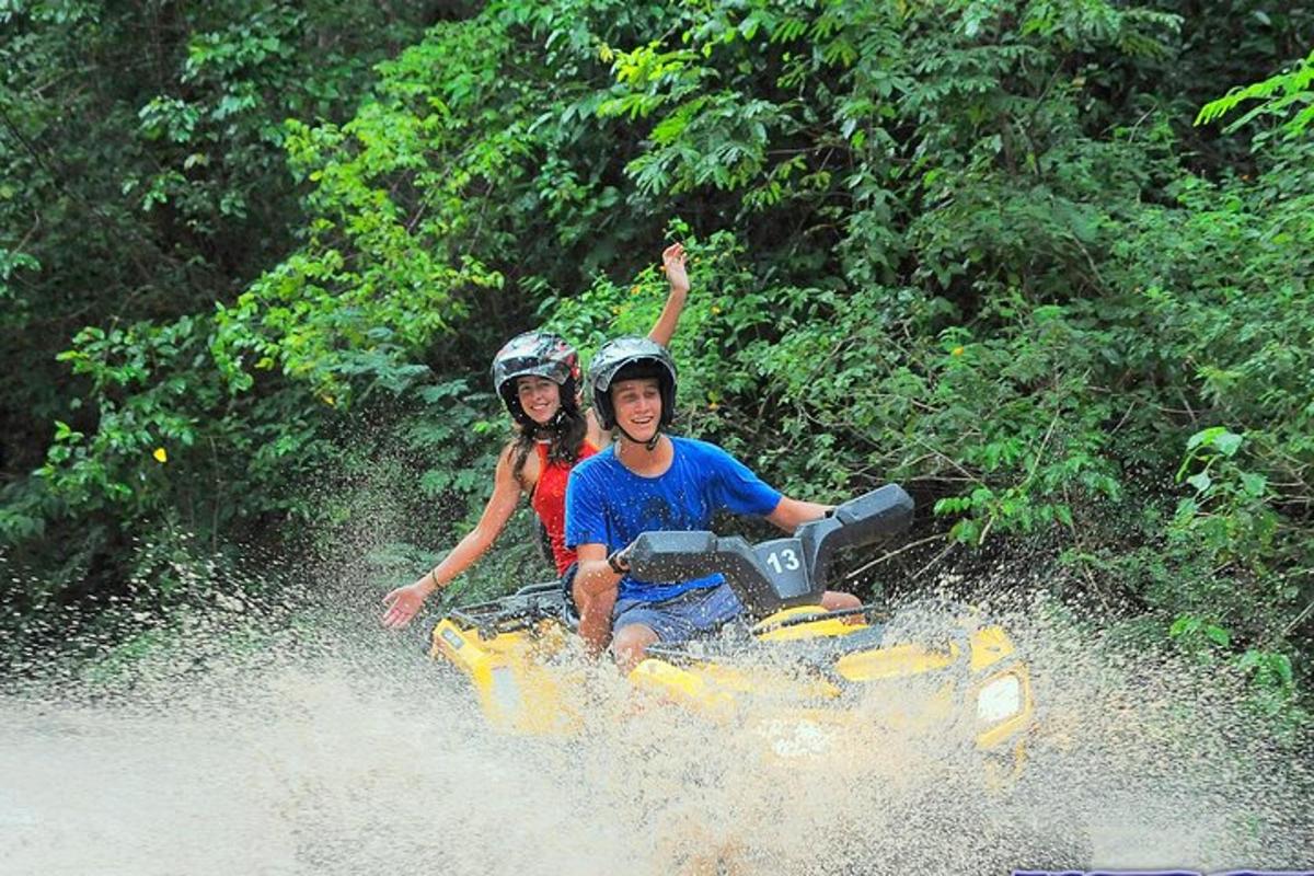 un uomo e una donna a bordo di un quad in acqua