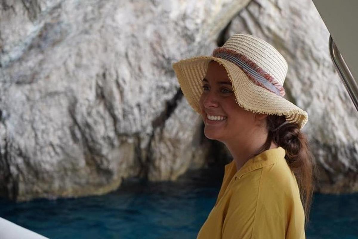 a woman wearing a hat and smiling on a boat