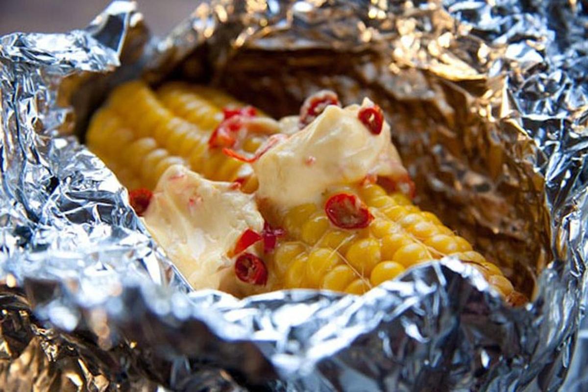 Un plato de mazorcas de maíz envueltas en papel de aluminio