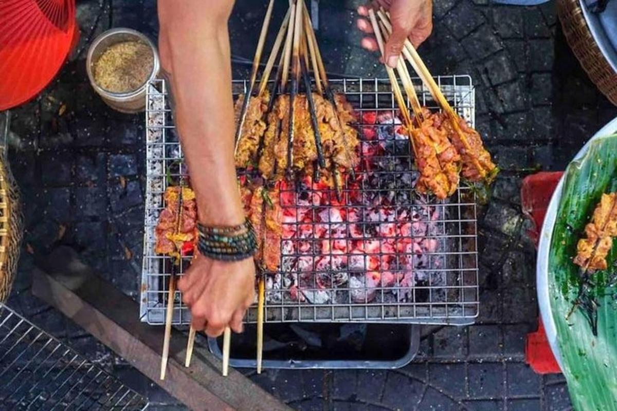 グリルの上で食べ物の入ったバスケットを持っている人