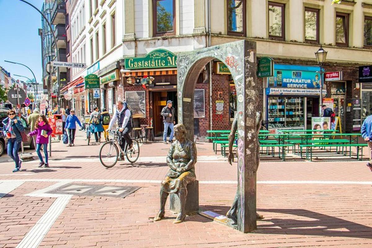 een standbeeld van een vrouw die op een bankje op een stadsstraat zit