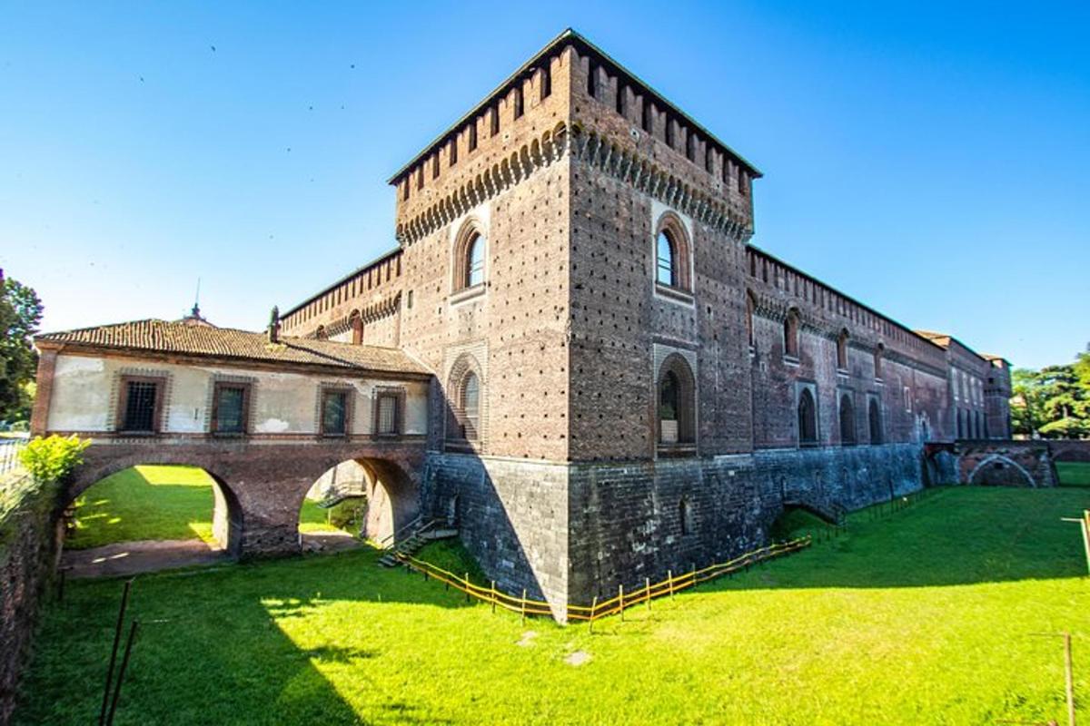 un gran edifici de maó amb un pont a l'herba