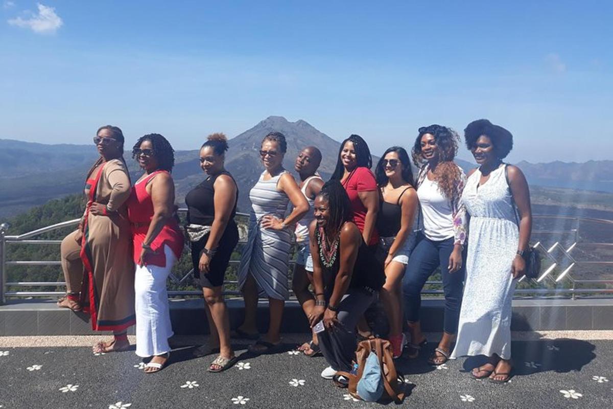 a group of women posing for a picture on the edge of a mountain