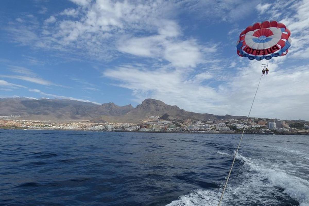 un grand cerf-volant volant au-dessus de l'eau sur un bateau