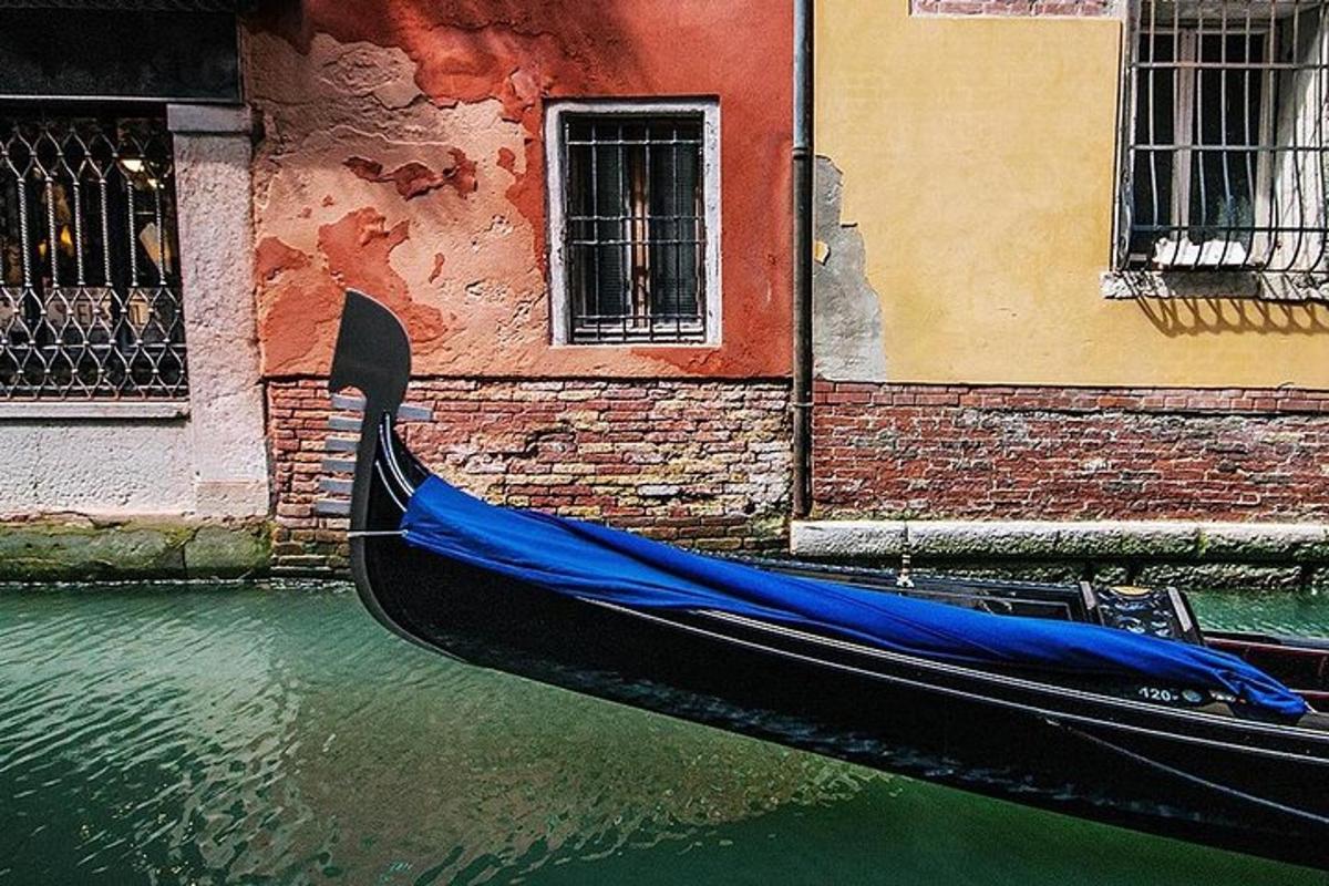 gondola dengan penutup biru duduk di dalam terusan