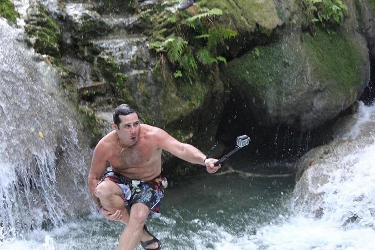 un home que sosté una pala en una cascada