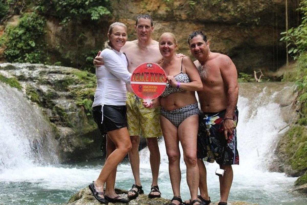 un grup de persones dretes sobre una roca davant d'una cascada