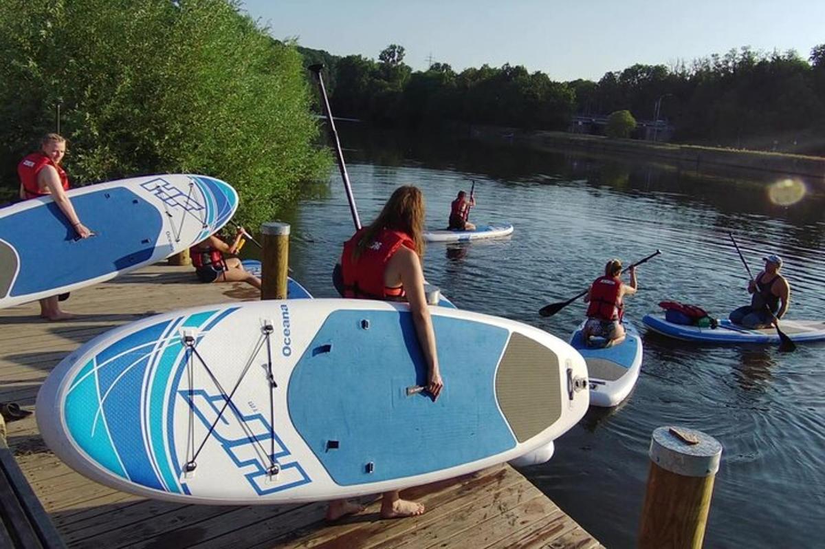 a group of people sitting on a dock with surfboards