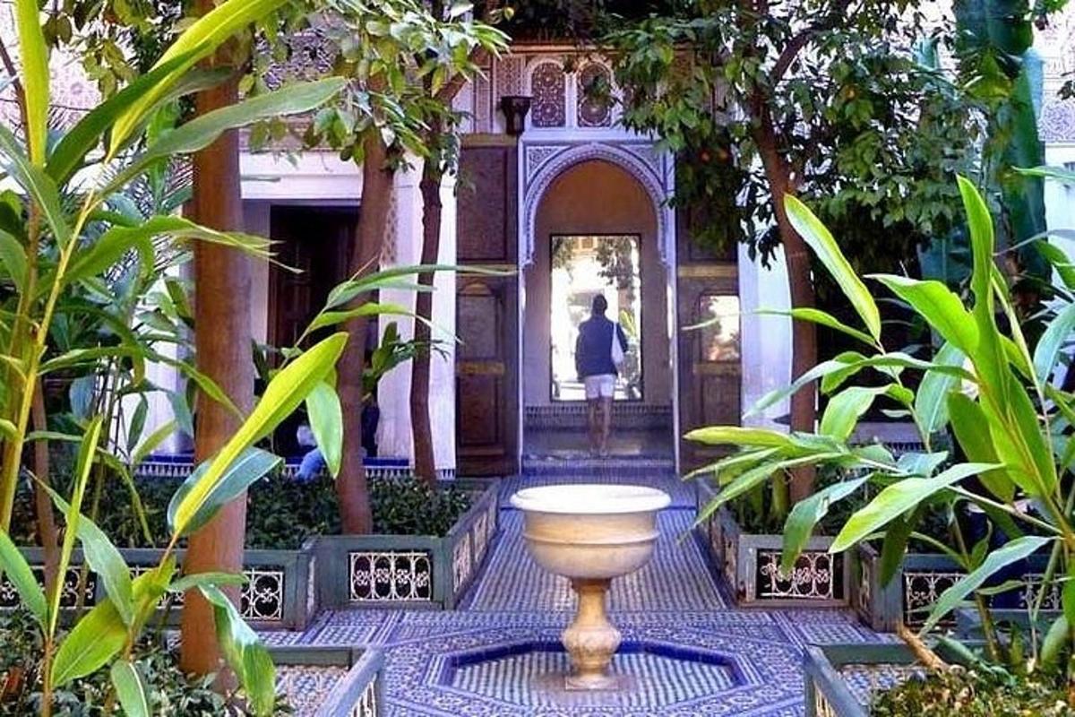seorang wanita berjalan ke dalam bangunan dengan pasu di taman