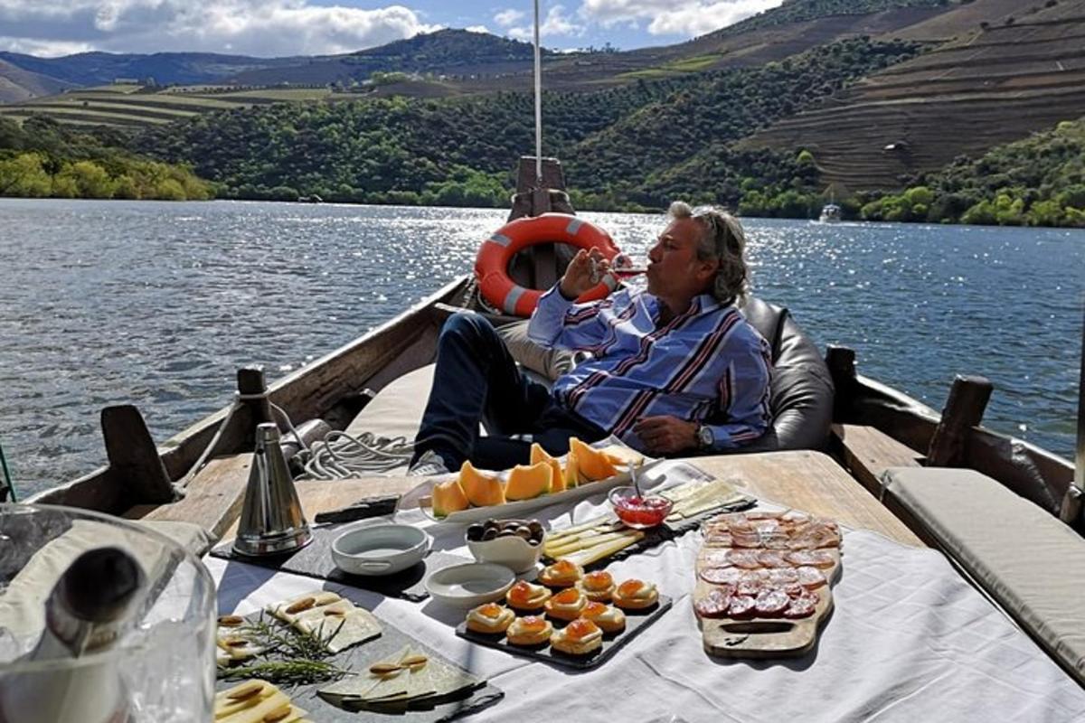 a man sitting on a boat eating food on a table