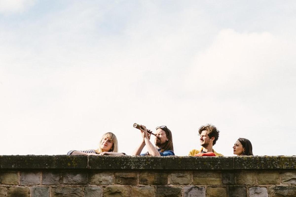 a group of people sitting on top of a wall
