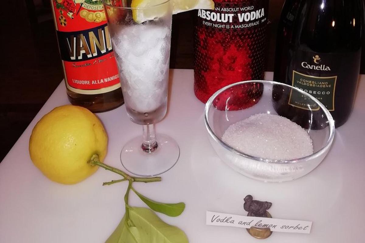 Una mesa con una bebida y un martini y un limón.