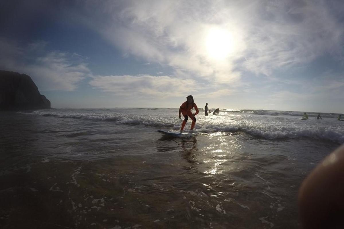 osoba stojaca na surfovej doske v oceáne