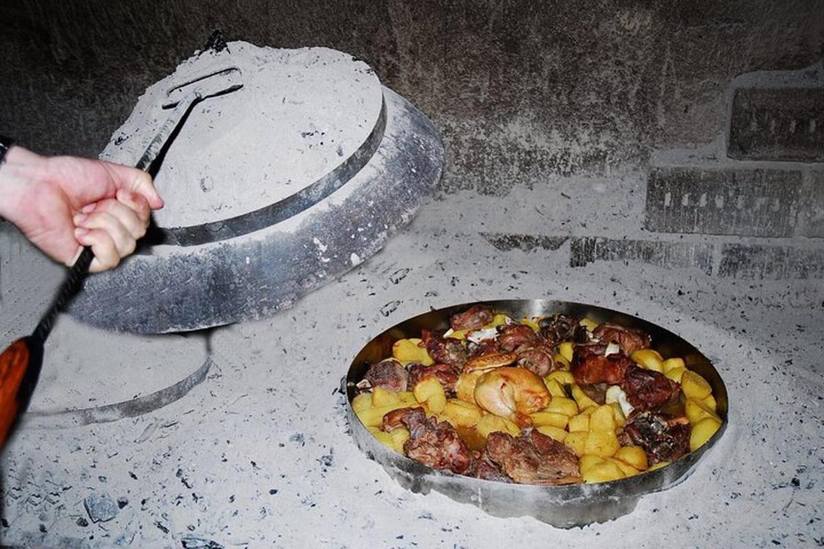 osoba držící špachtli vedle pánve s jídlem
