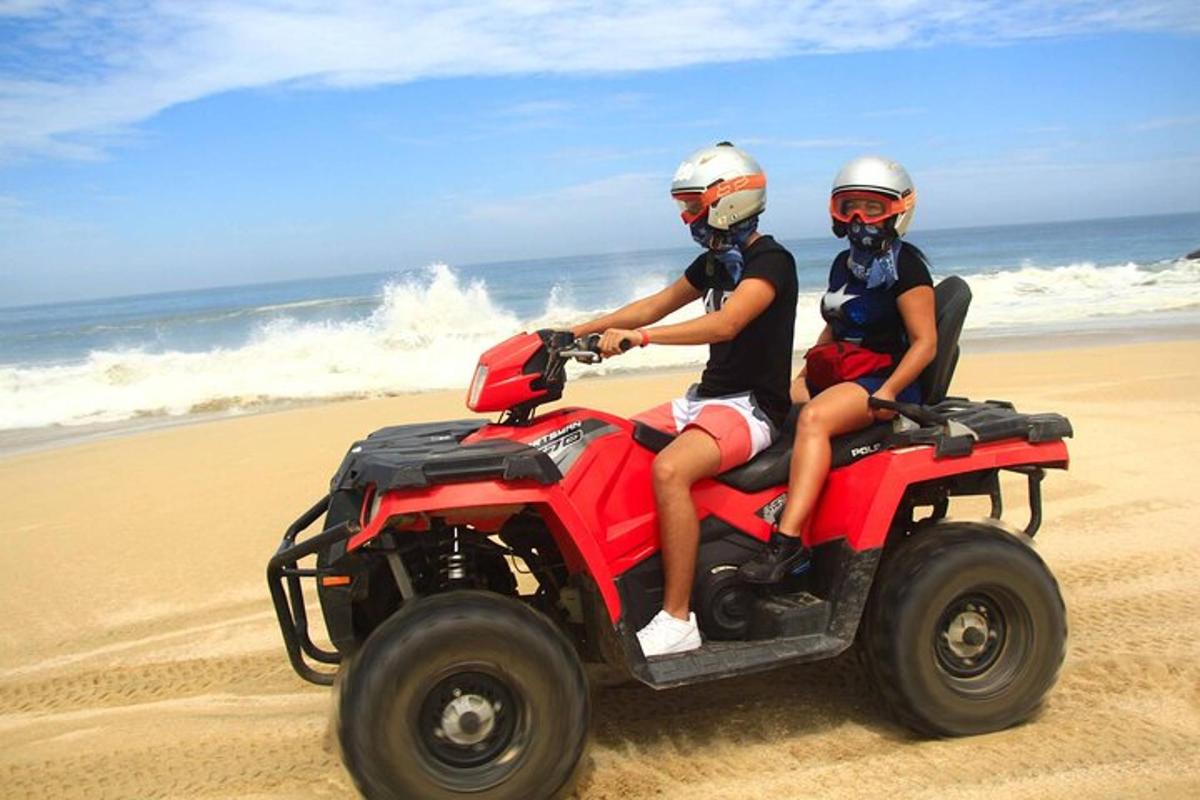 dua orang menaiki kenderaan empat roda di pantai