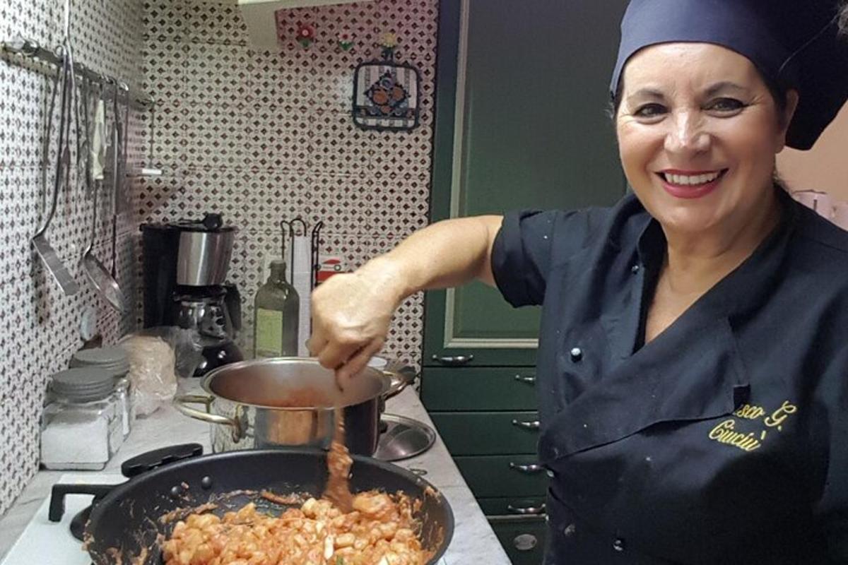 una dona a la cuina cuinant menjar en una paella