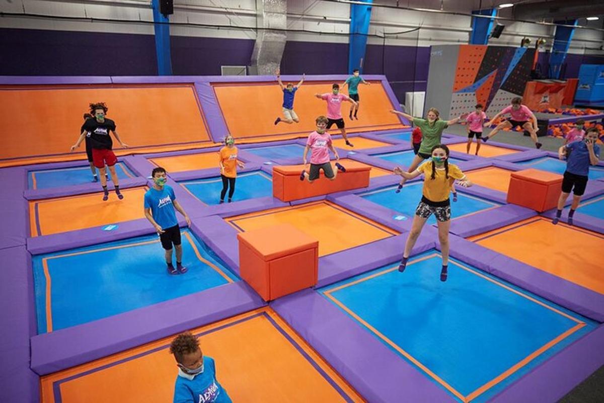 Skupina dětí si hraje v krytém trampolínovém parku