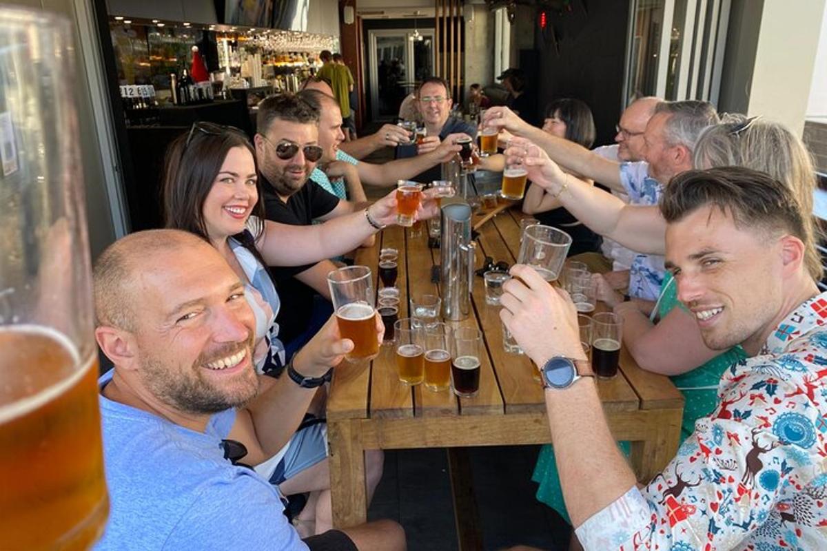 Un grupo de personas sentadas alrededor de una mesa bebiendo cerveza.