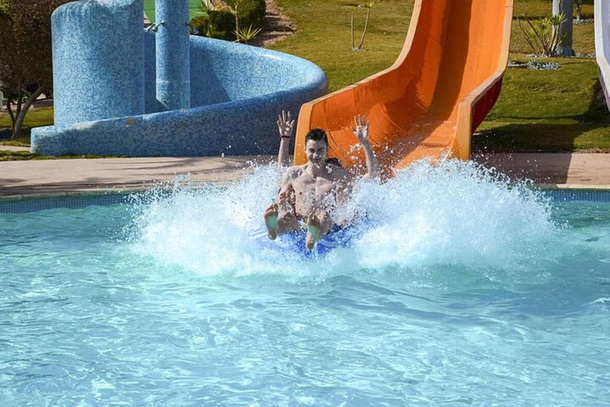 un home pujant a un tobogan aquàtic en una piscina