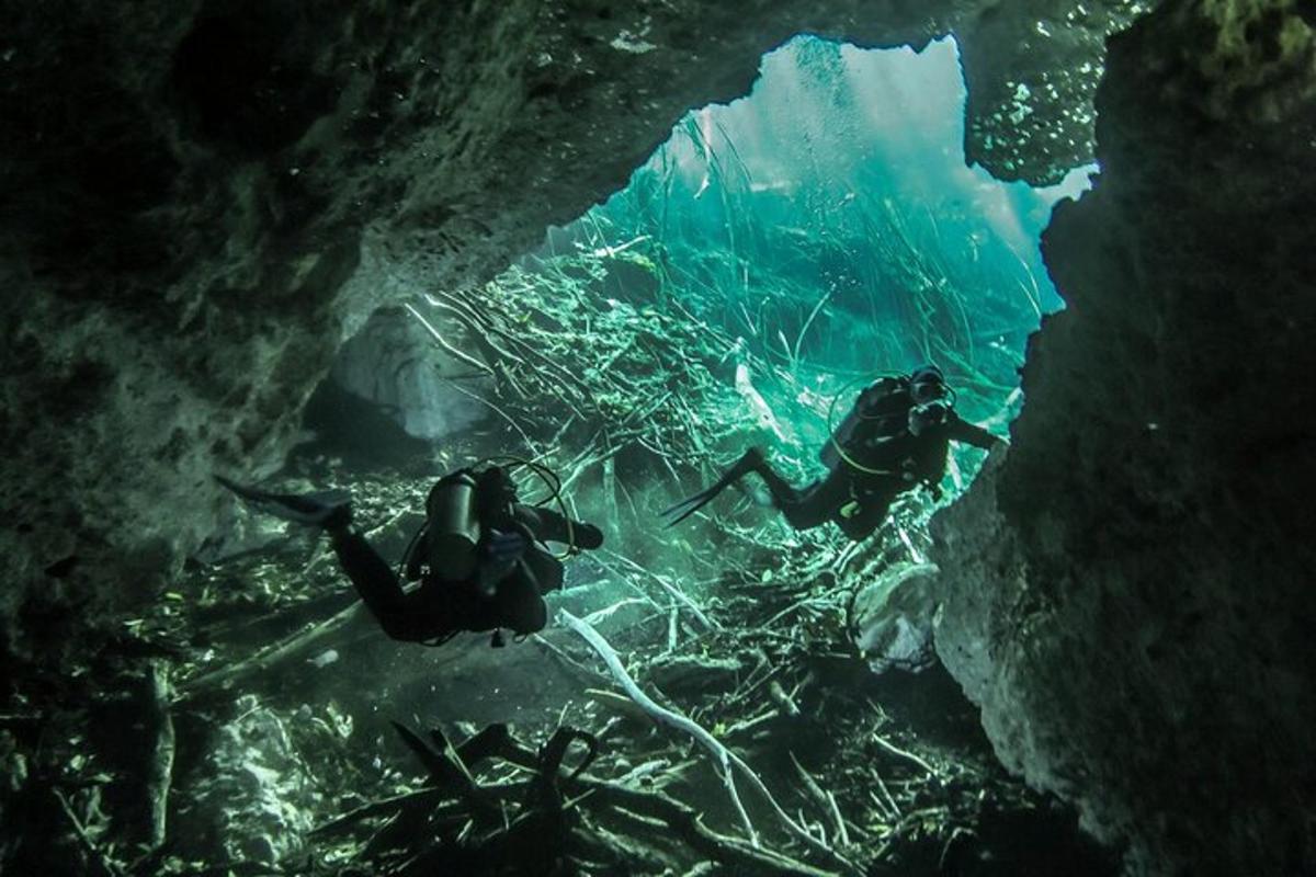 two people are swimming in an underwater cave