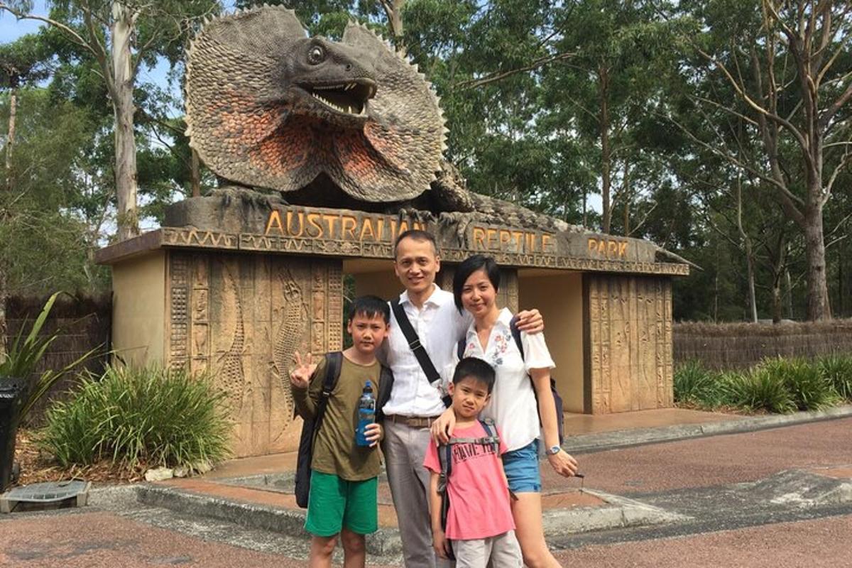 Ein Mann und zwei Kinder stehen vor einem Dinosaurierdenkmal