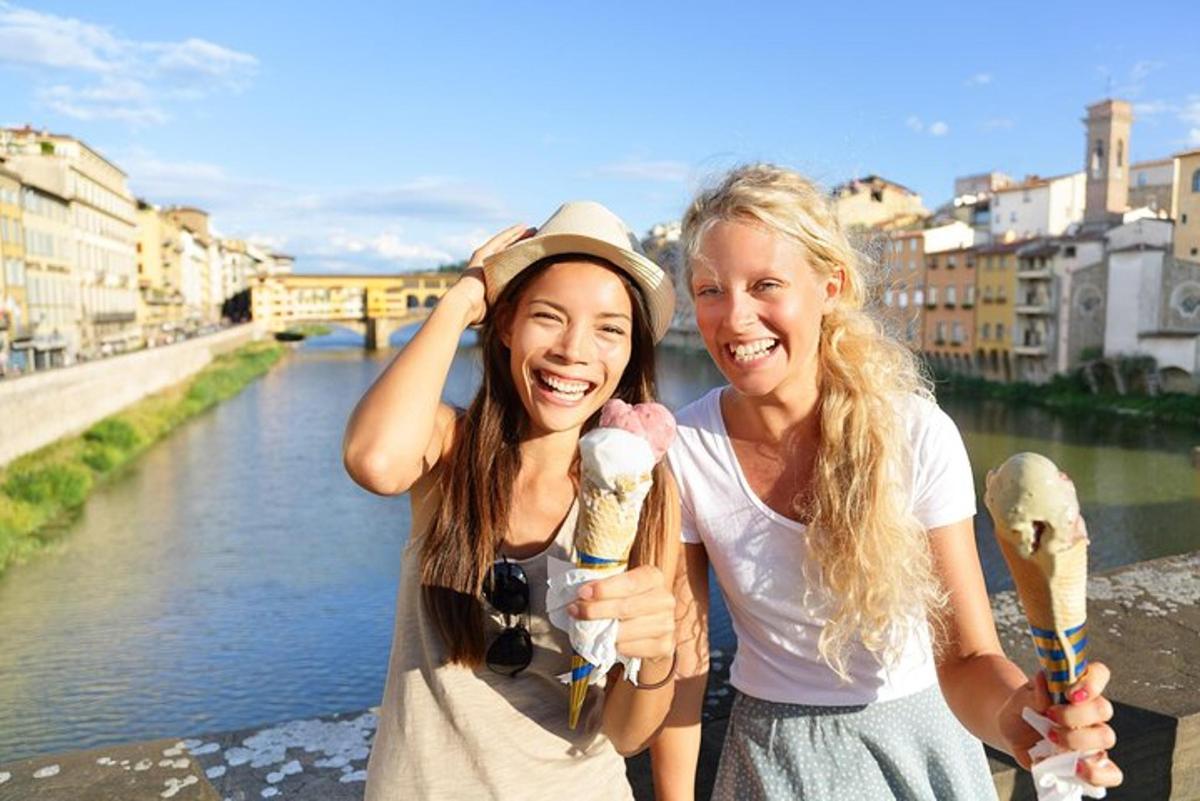 zwei Frauen stehen neben einem Fluss und halten ein Eis