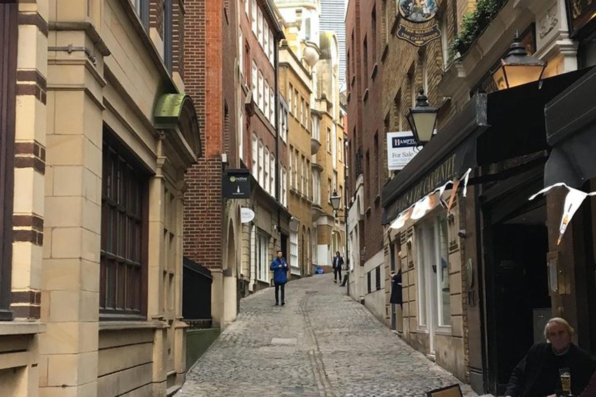 Una mujer caminando por un callejón entre edificios.