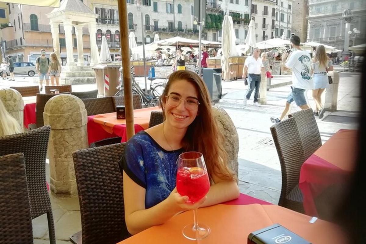 una dona asseguda a una taula amb una beguda