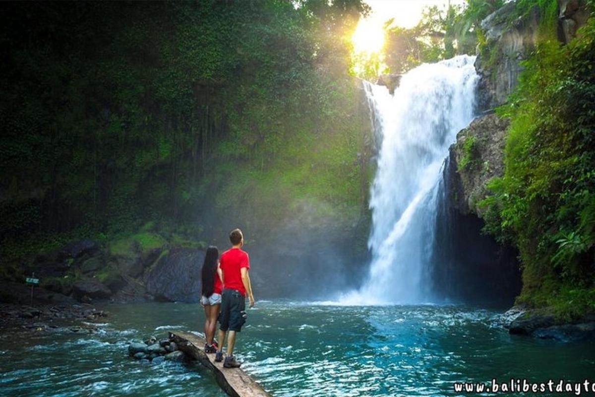 một người đàn ông và một người phụ nữ đứng trên cầu trước thác nước