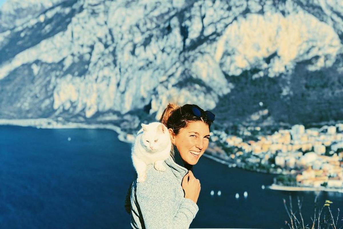 Una mujer sosteniendo un gato blanco en sus brazos