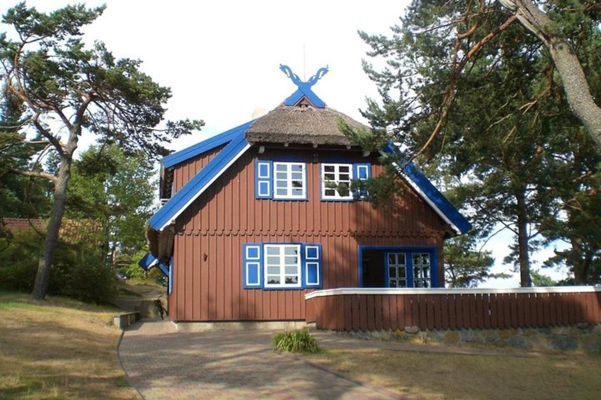 sebuah rumah kecil berwarna merah dengan bumbung biru