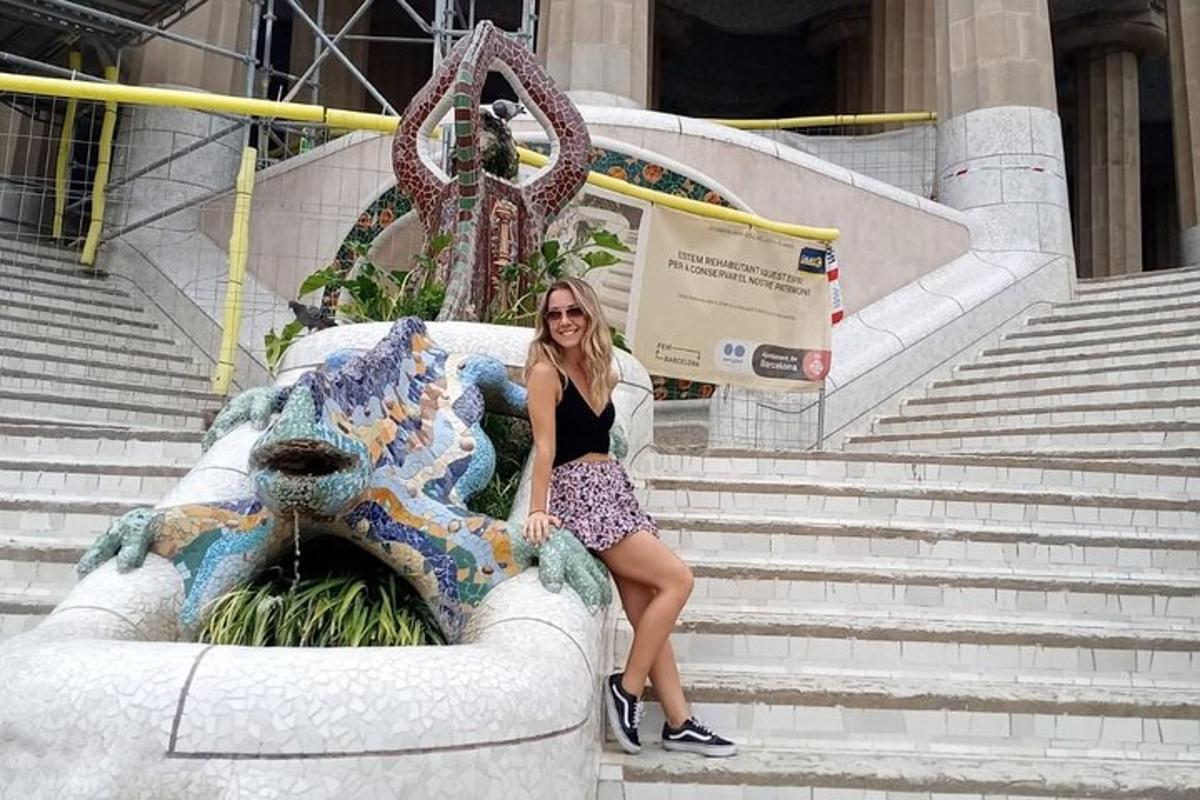 a woman sitting on a statue in front of a fountain