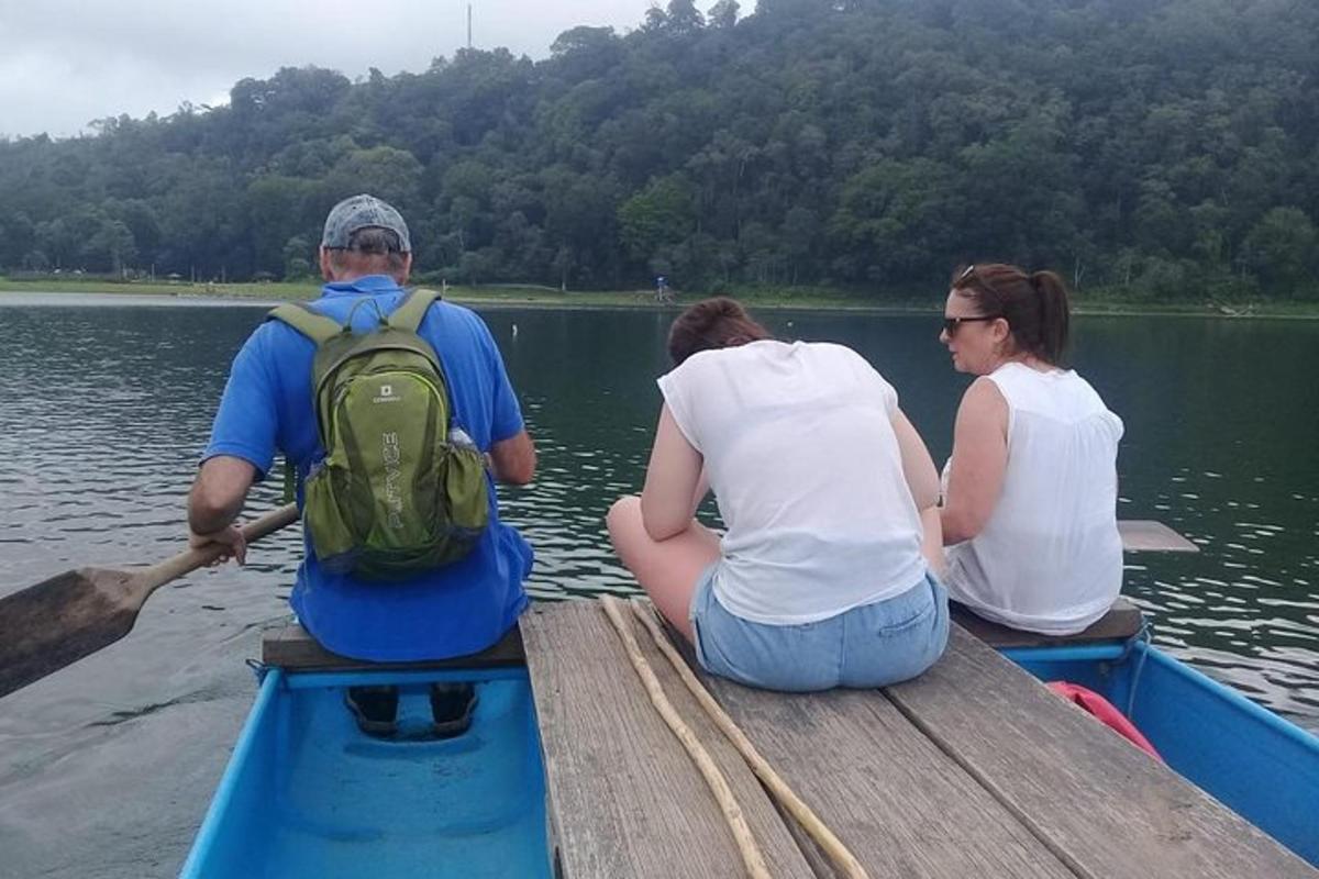 สามคนนั่งอยู่บนเรือบนน้ำ