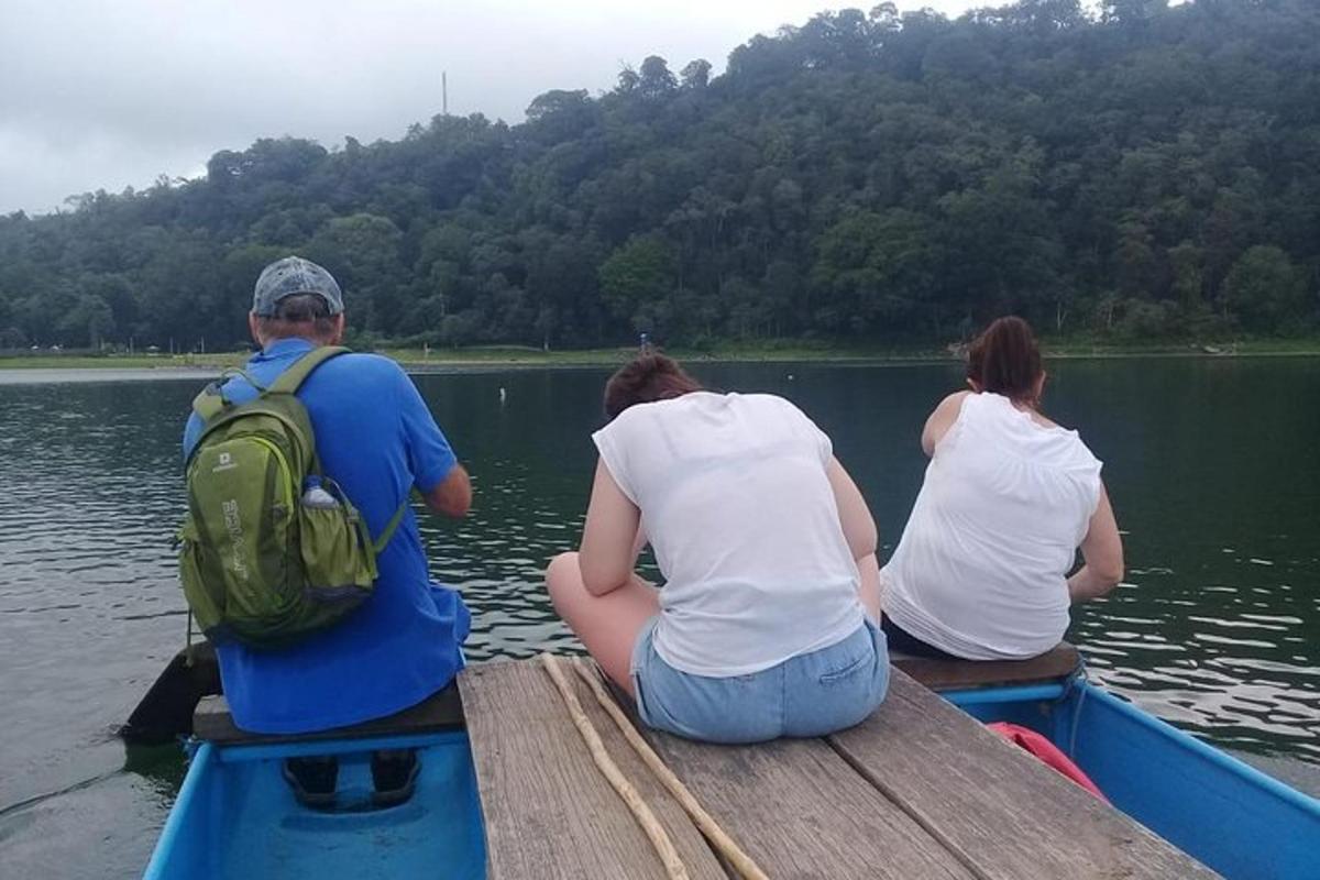 สามคนนั่งอยู่บนเรือในน้ำ