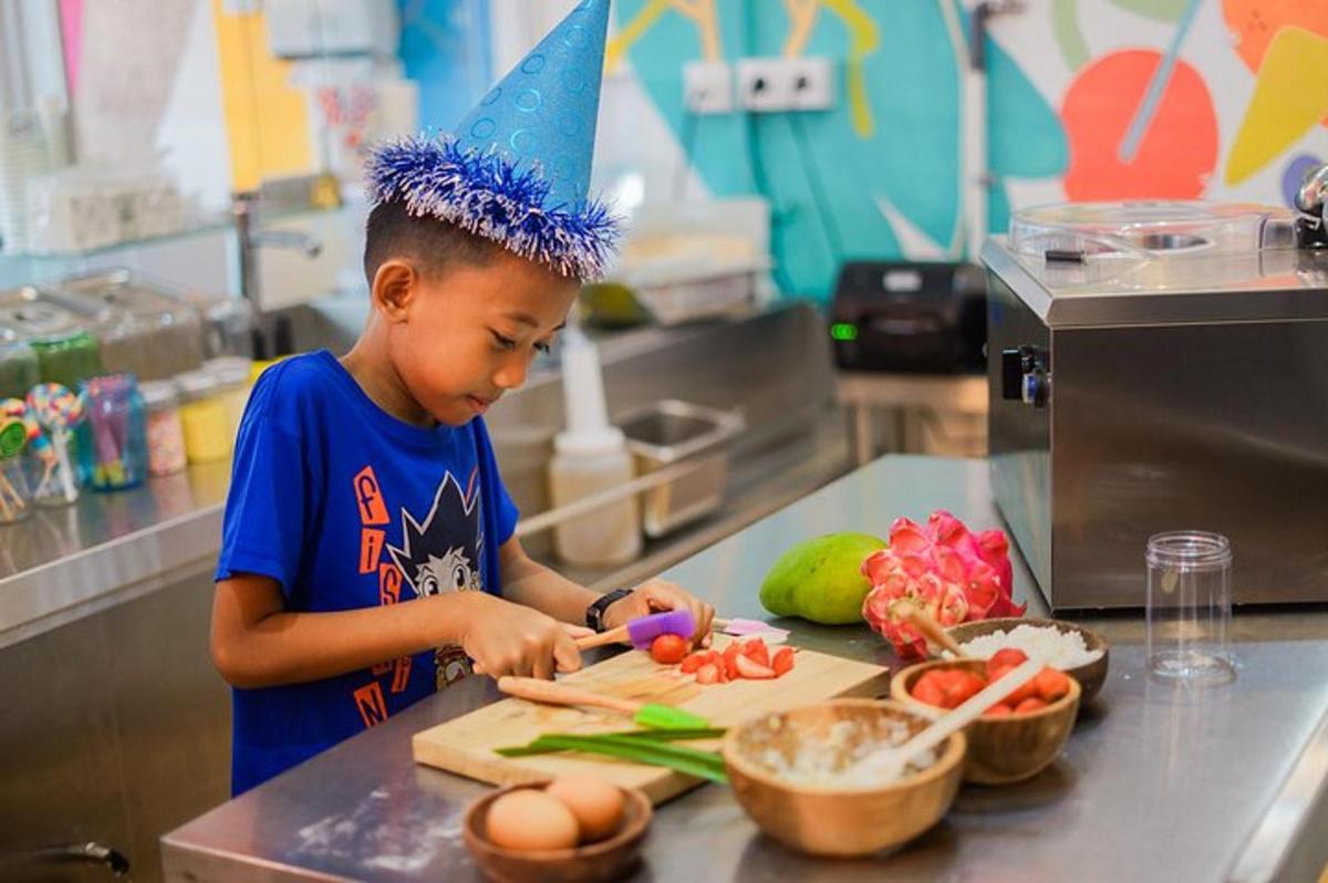 un garçon avec un chapeau d'anniversaire coupant des légumes sur une planche à découper
