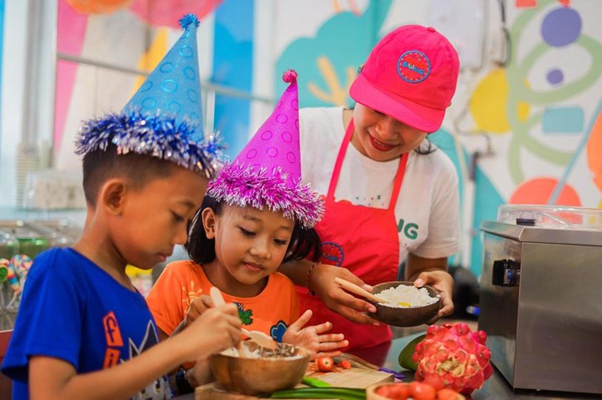 deux enfants portant des chapeaux d'anniversaire mangeant de la nourriture avec une femme