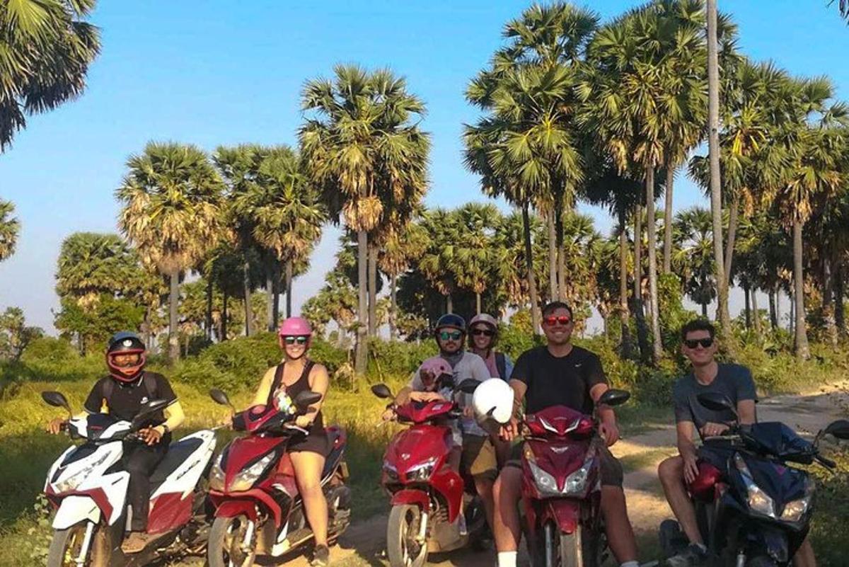 a group of people riding motorcycles on a road with palm trees