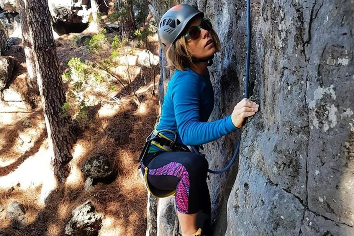 una mujer está en una pared de roca