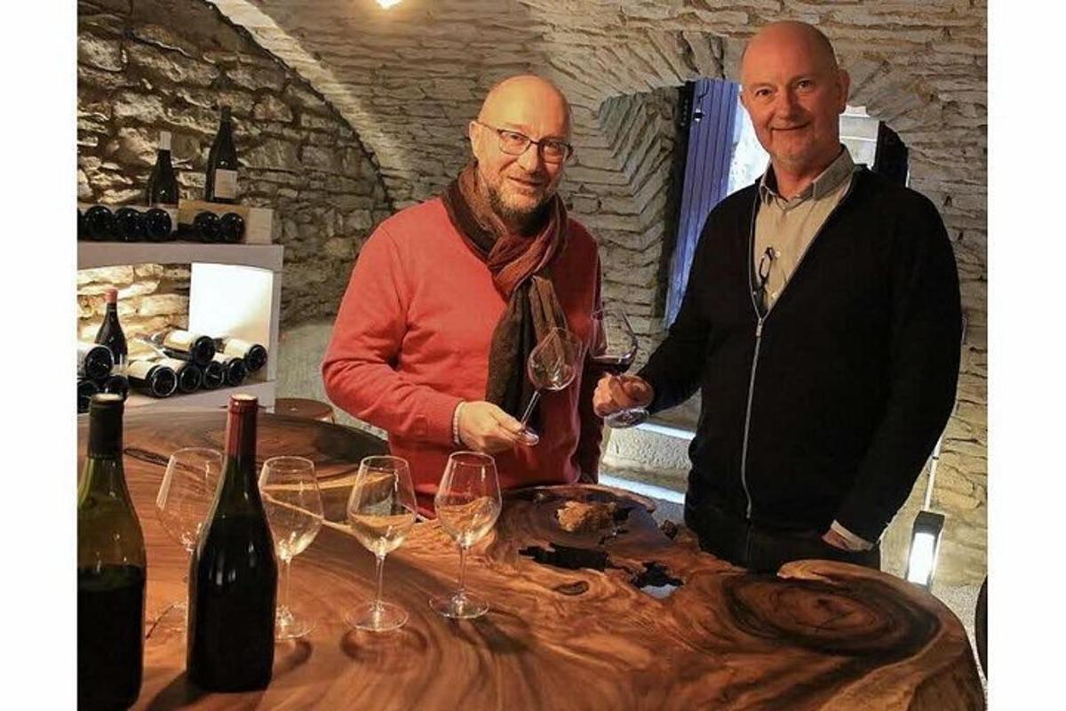 two men standing at a table with wine glasses