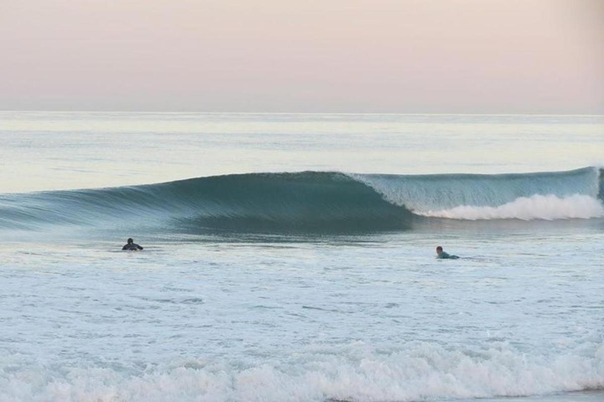 doi oameni călărind un val în ocean