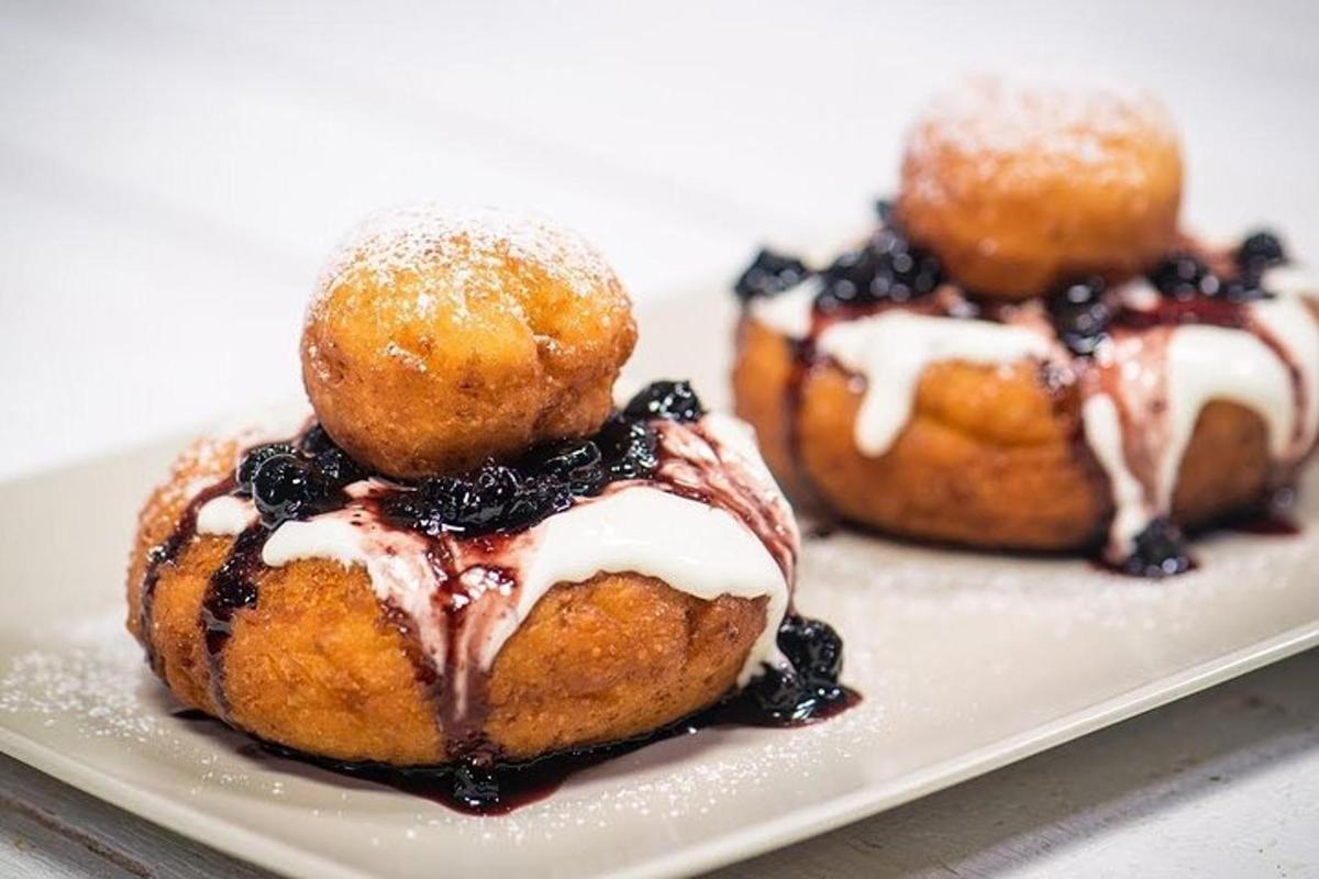 three pastries with blueberries and powdered sugar on a plate