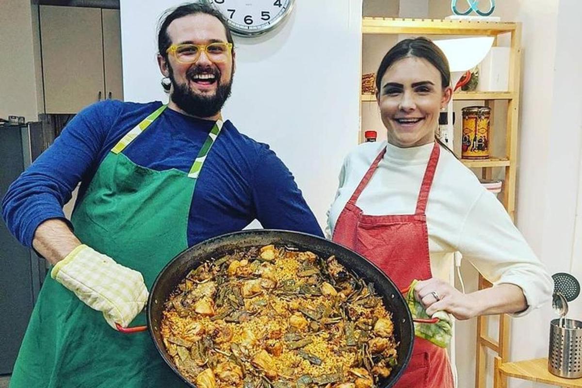 a man and a woman holding a pan of food