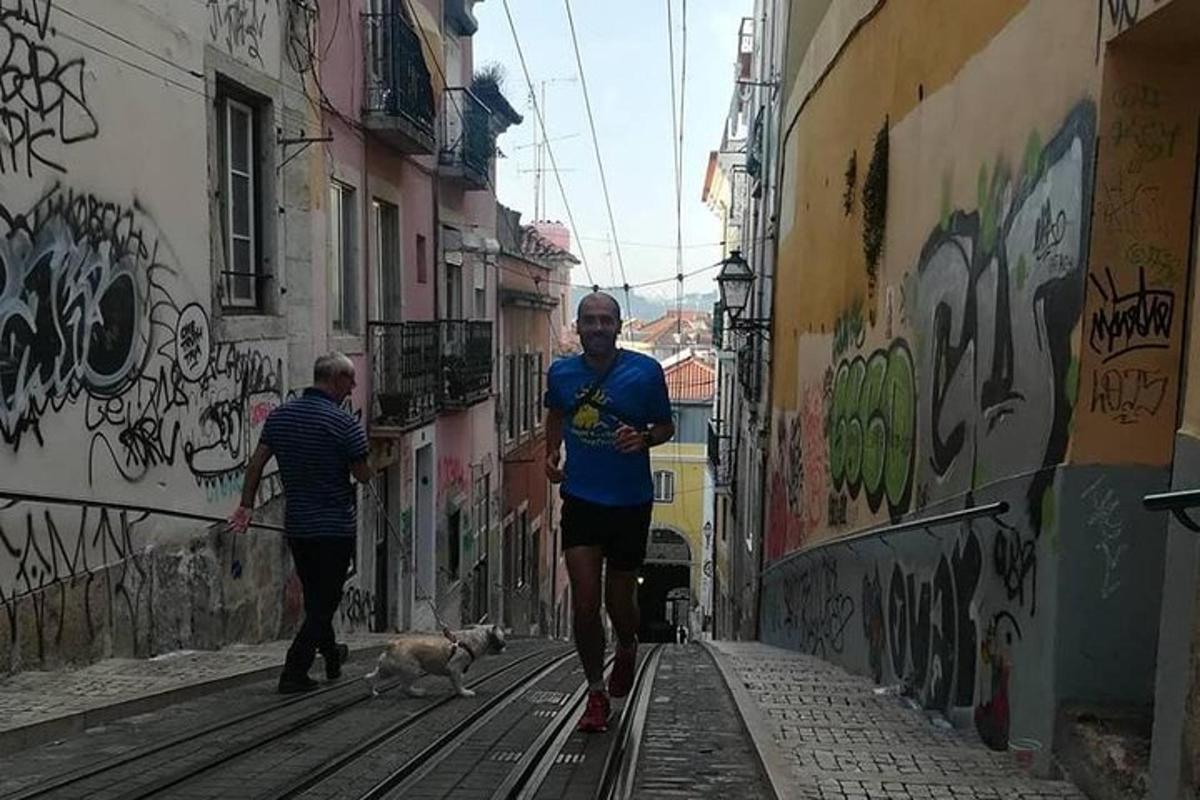 en mann som går tur med hunden sin på en gate med graffiti