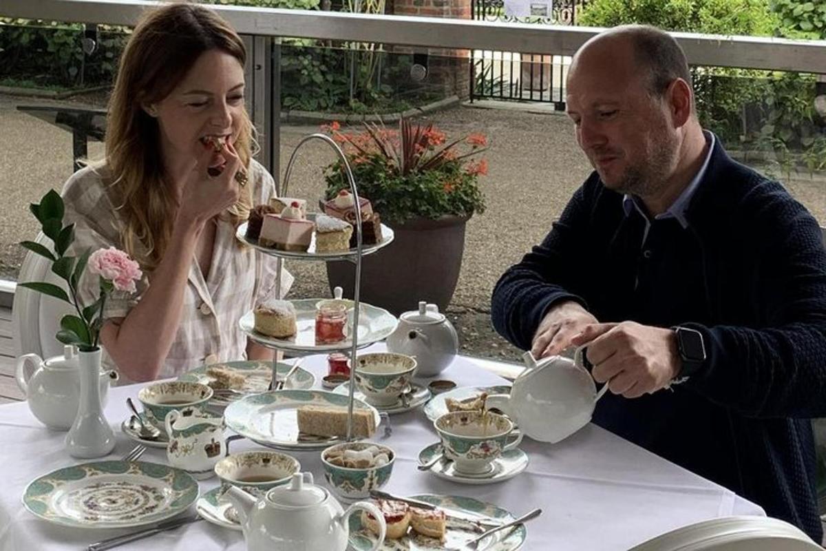 um homem e uma mulher sentados à mesa tomando chá