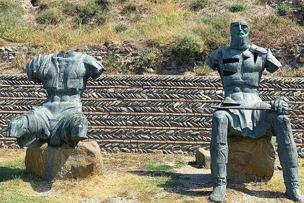 a statue of a man sitting on a rock