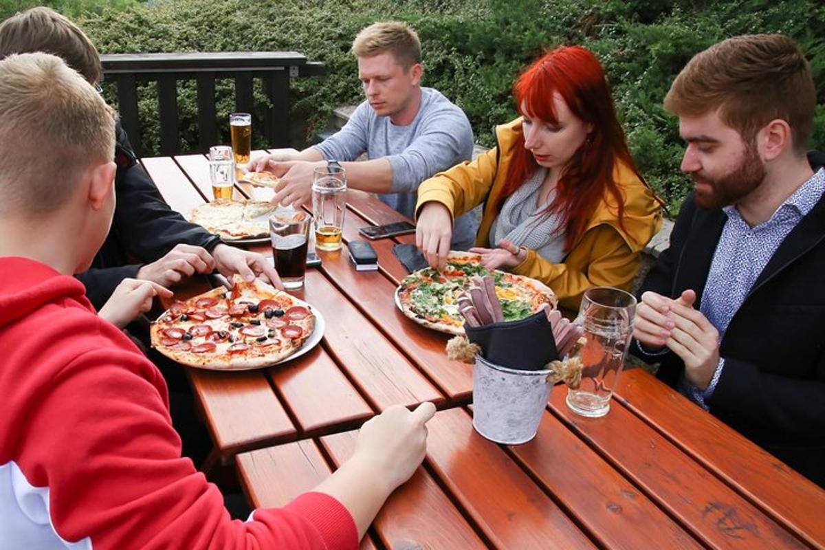 un gruppo di persone sedute a un tavolo che mangiano la pizza