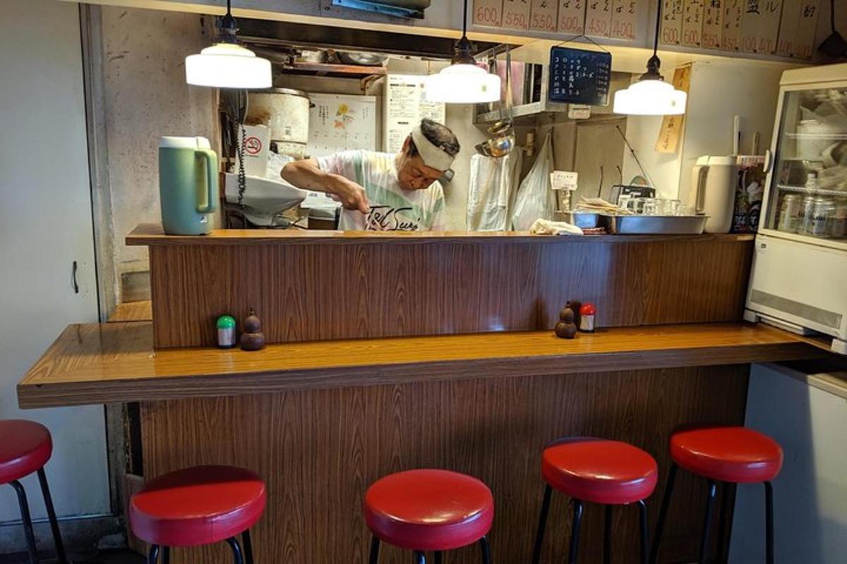 muž připravující jídlo v restauraci s červenou stoličkou