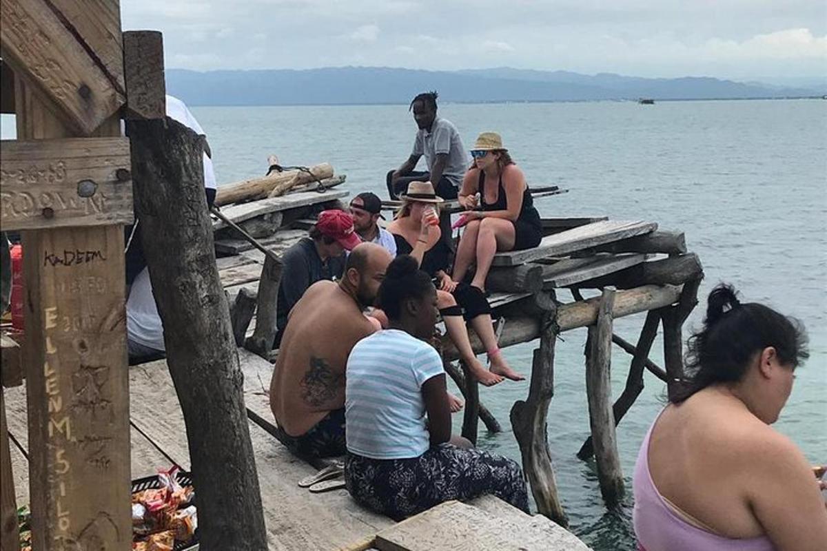 un gruppo di persone sedute su un molo in acqua