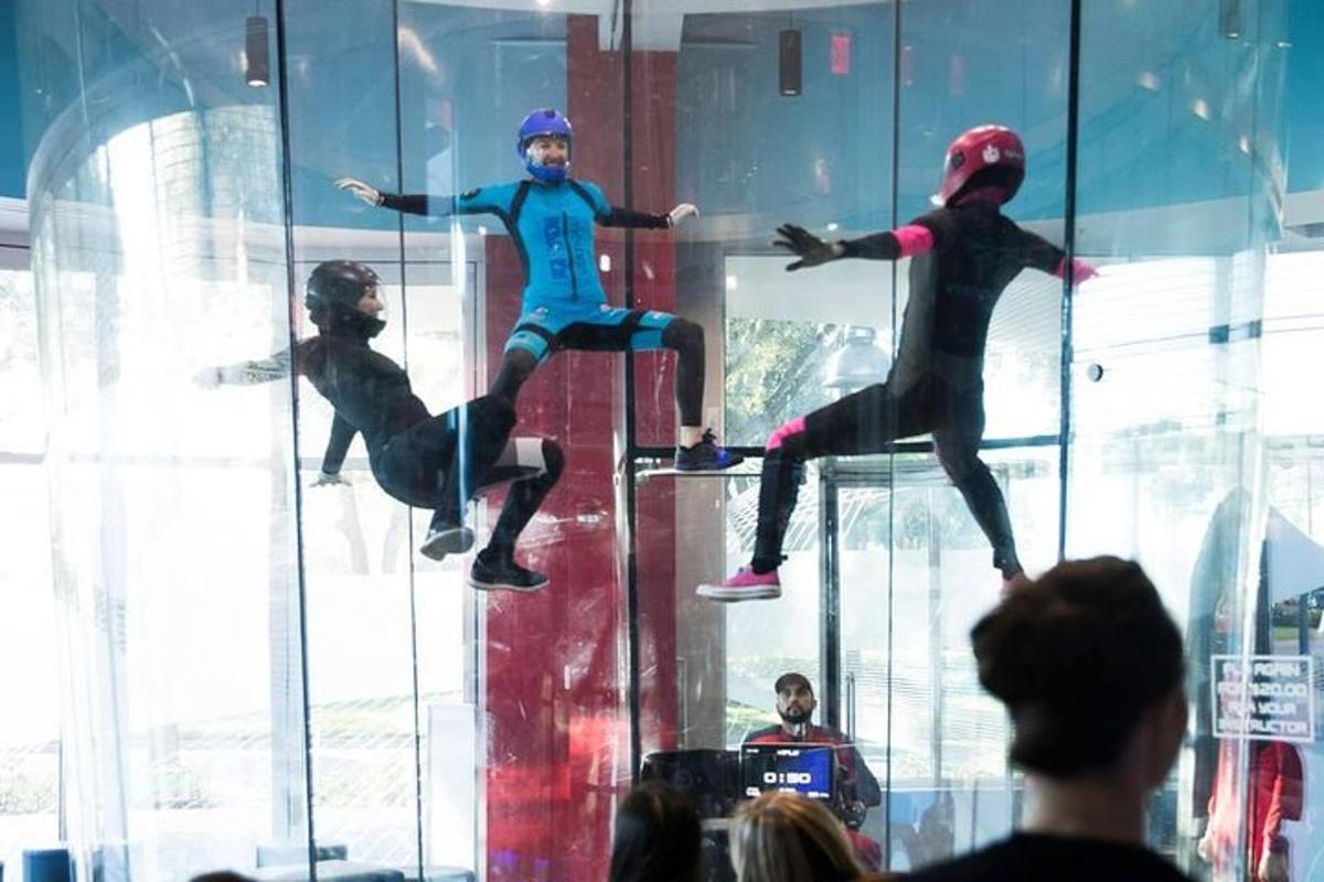 un gruppo di persone che osserva tre persone esposte in una stanza